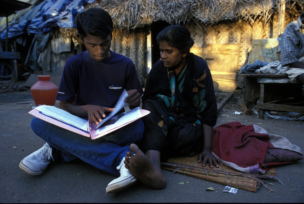 15-year-old Ramesh showing his prized book of letters and cards to his mother