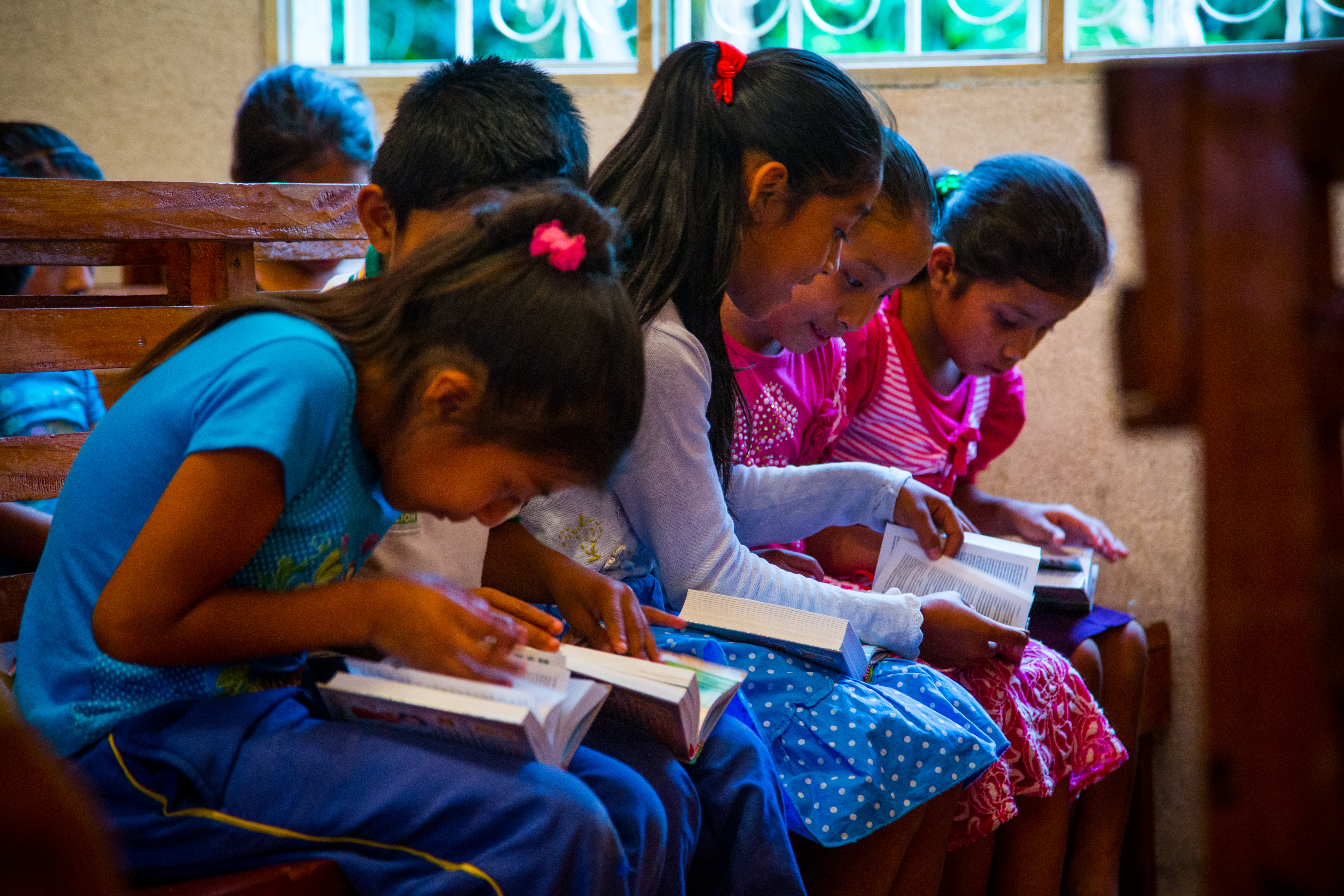 Girls at the project reading their new Bibles