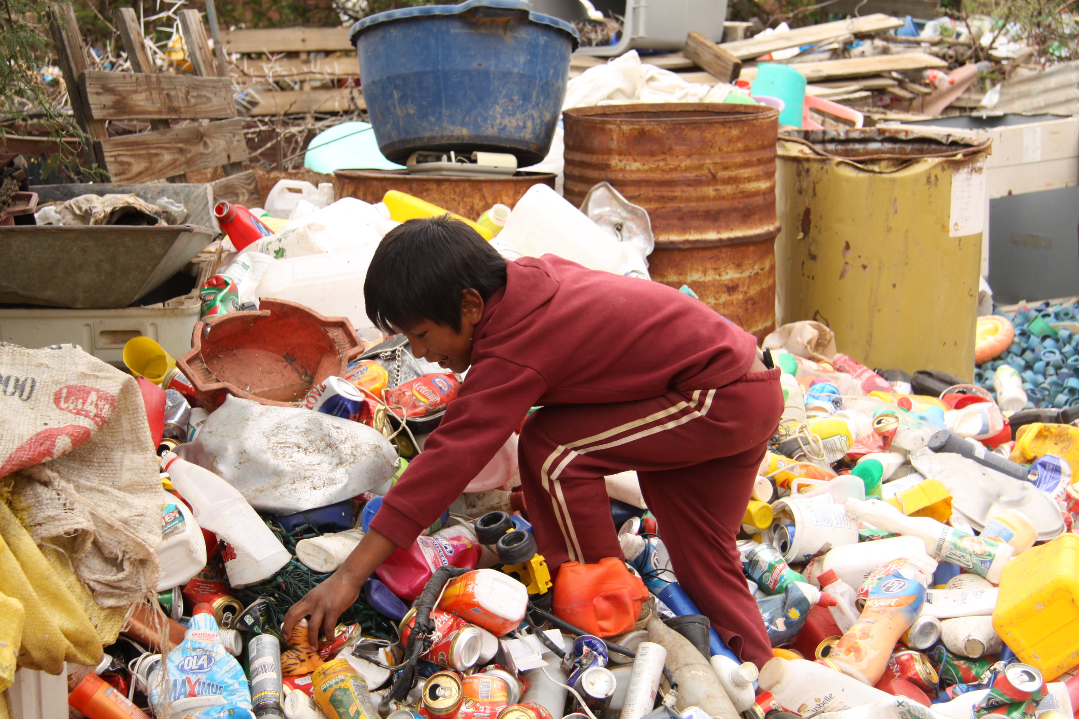 Bolivian sponsored child searches through rubbish