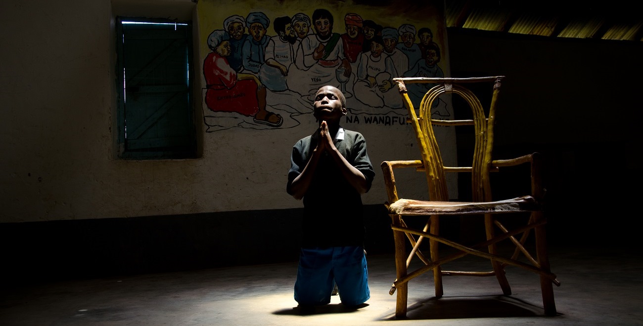 Julius praying at his Compassion project