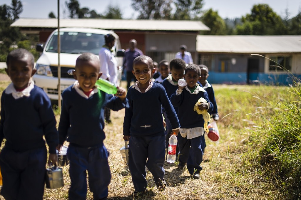 Sponsored children walking to the woodwork shed