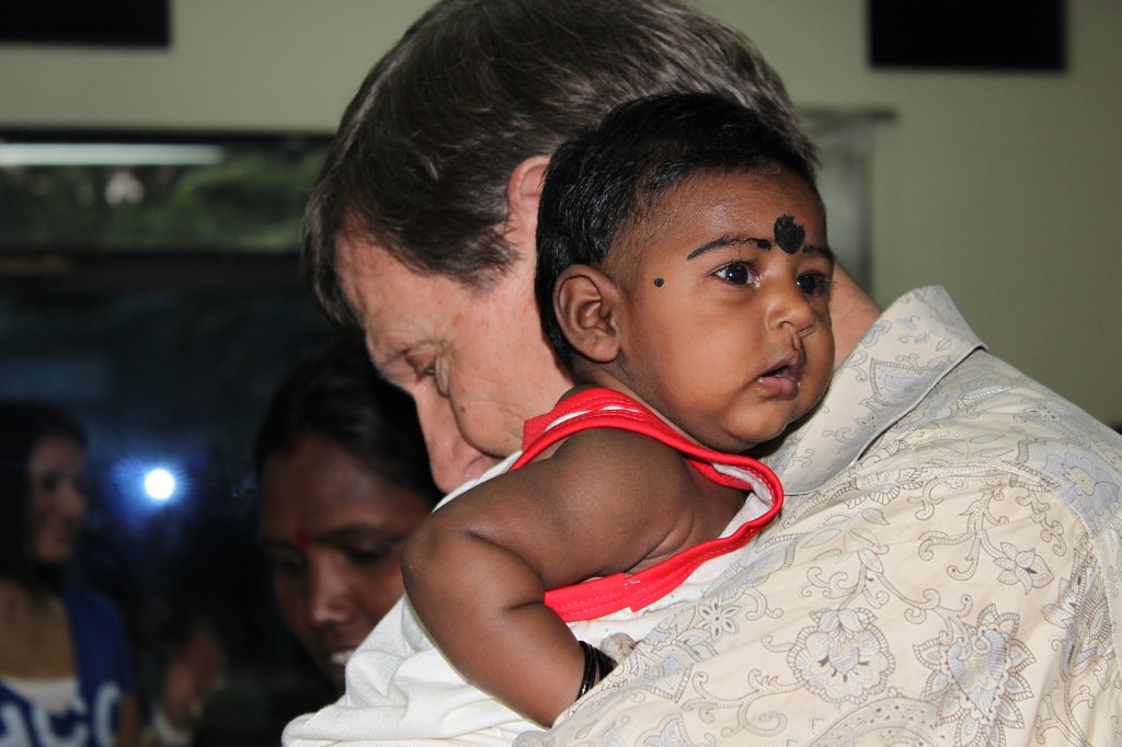 Wess Stafford cradling baby