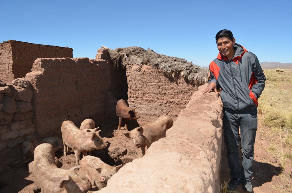 Miguel next to his pig pen