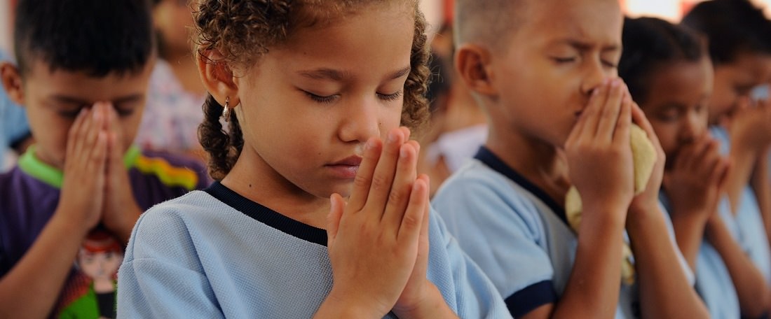 Children praying in Colombia