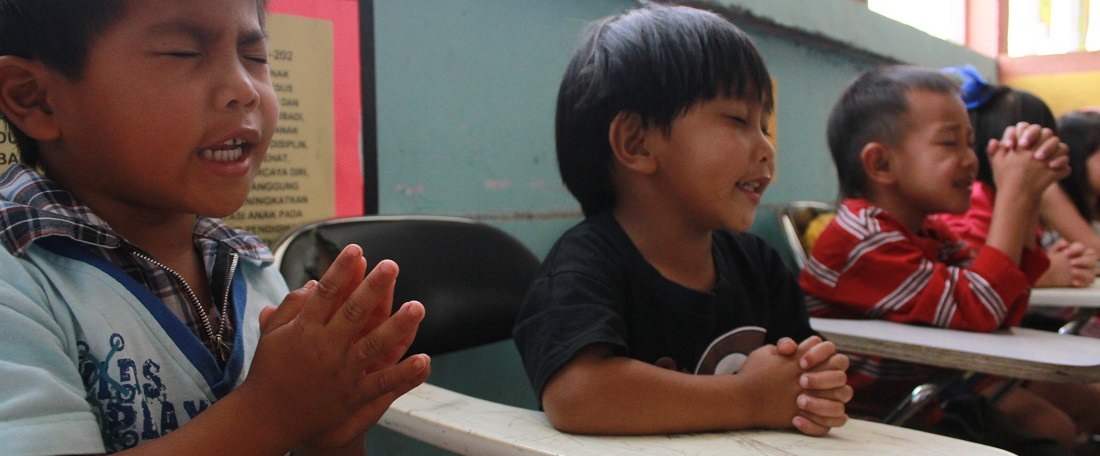 Children praying in Indonesia