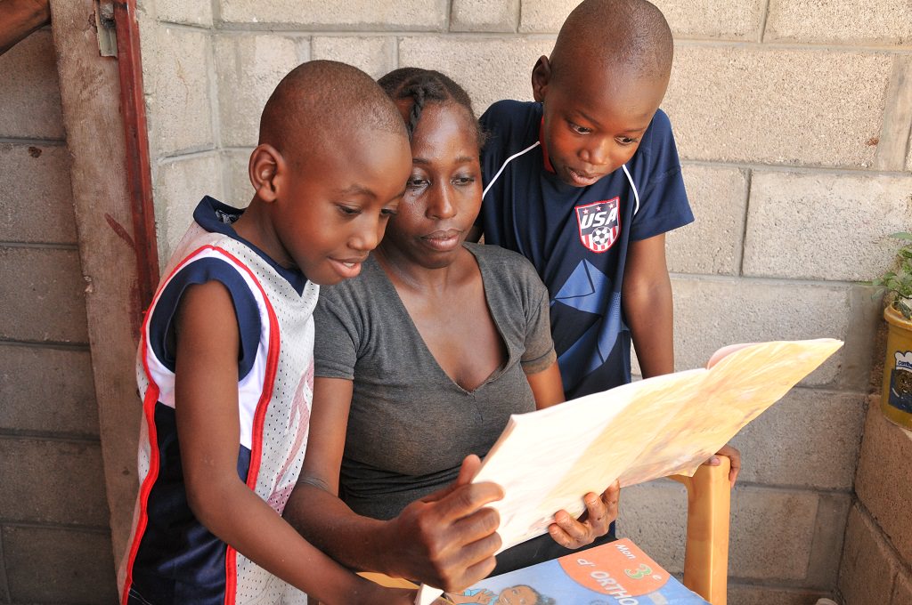 Haitian boys showing their mum their homework