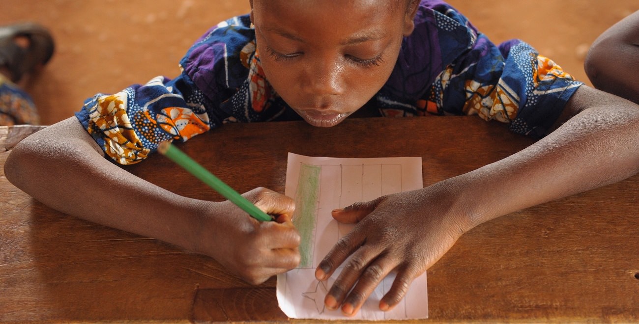 Boy colouring on bench