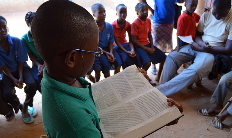 Boy reading Bible in Tanzania