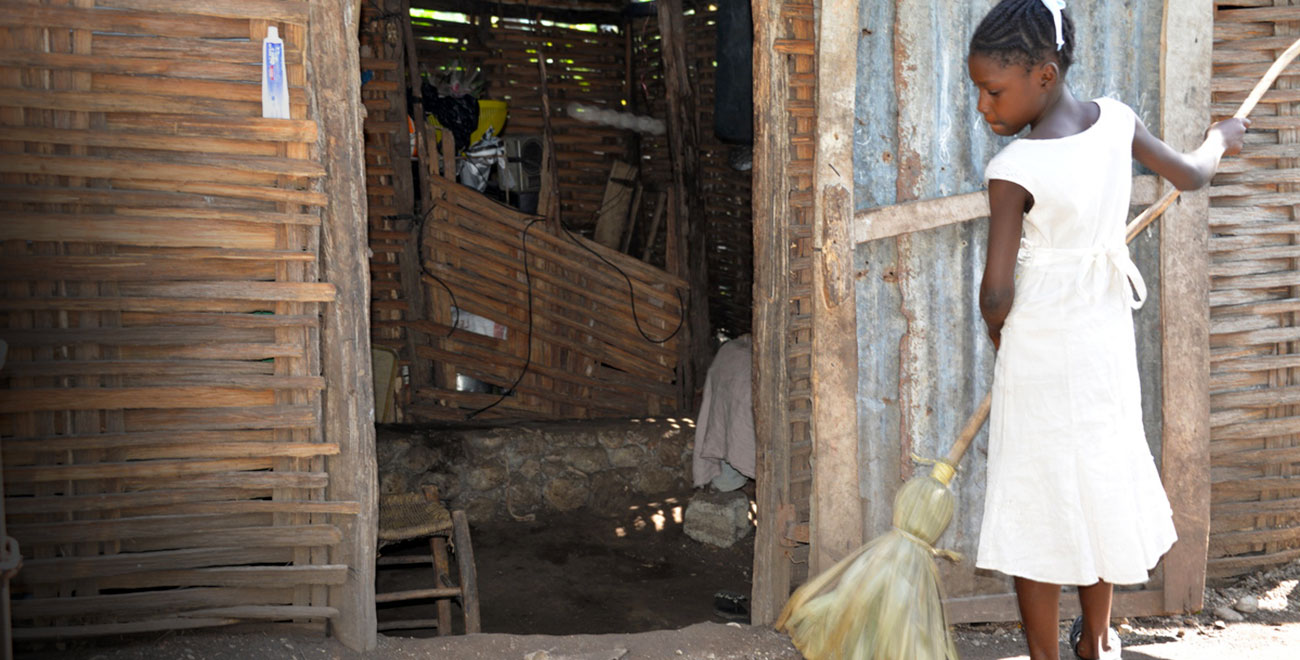 Girl sweeping in Haiti