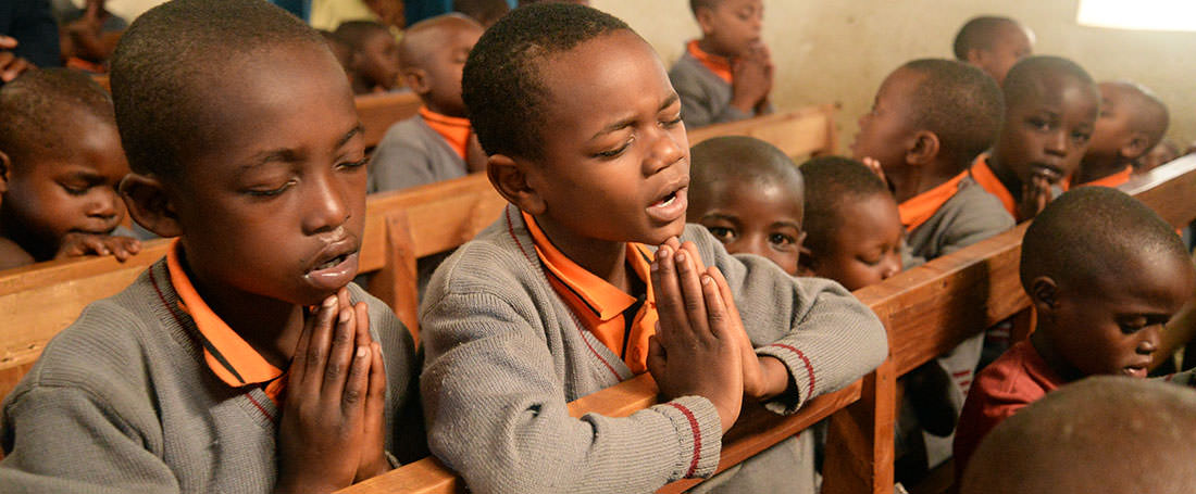 Boys praying in Uganda