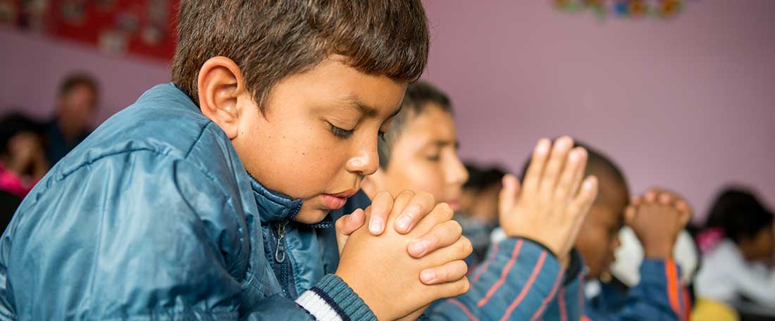 Boys praying in Ecuador