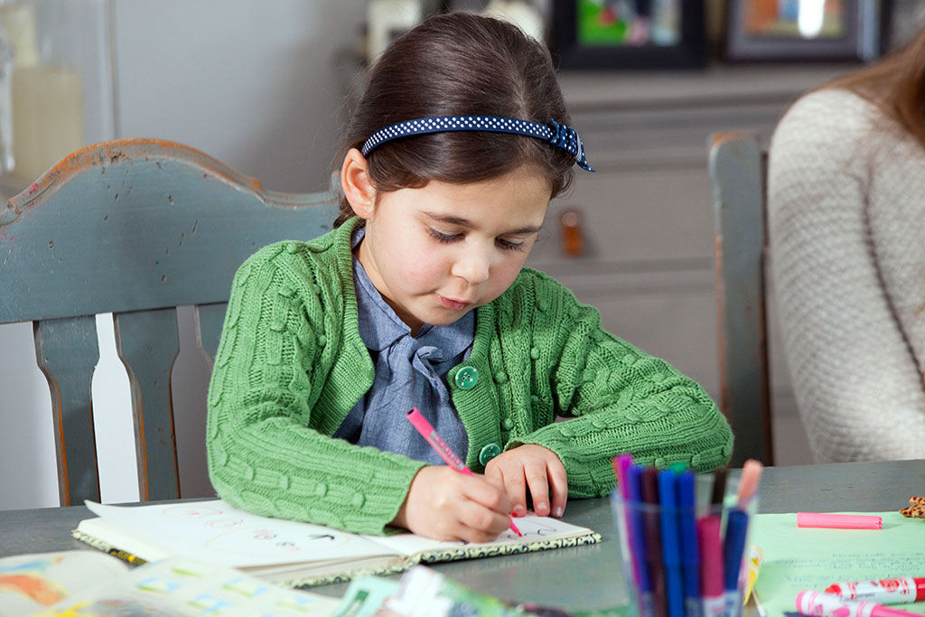 Child writing a letter to her sponsored child