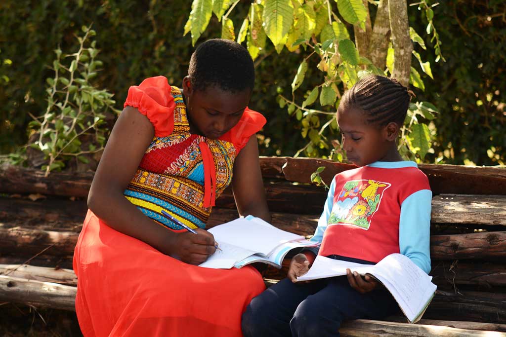 Sponsored child Ruth teaching her sister