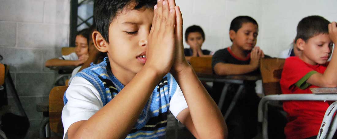 Boy praying in El Salvador