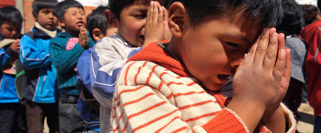 Boys praying in Bolivia