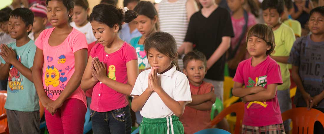 Children praying in Ecuador