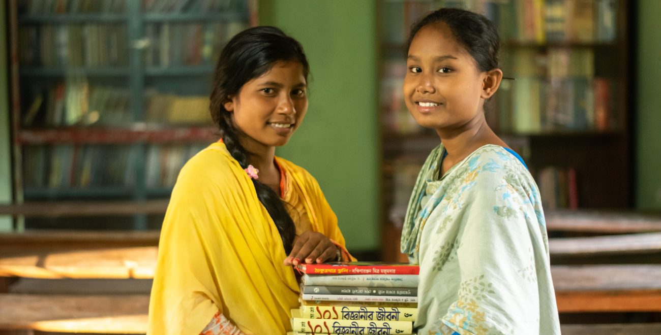 Ripa and Eti hold a pile of books