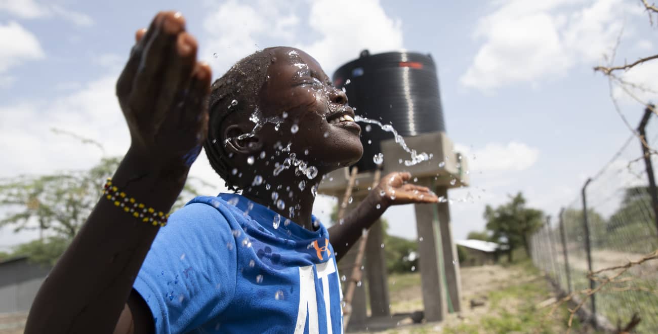 Rehema splashes herself with clean water