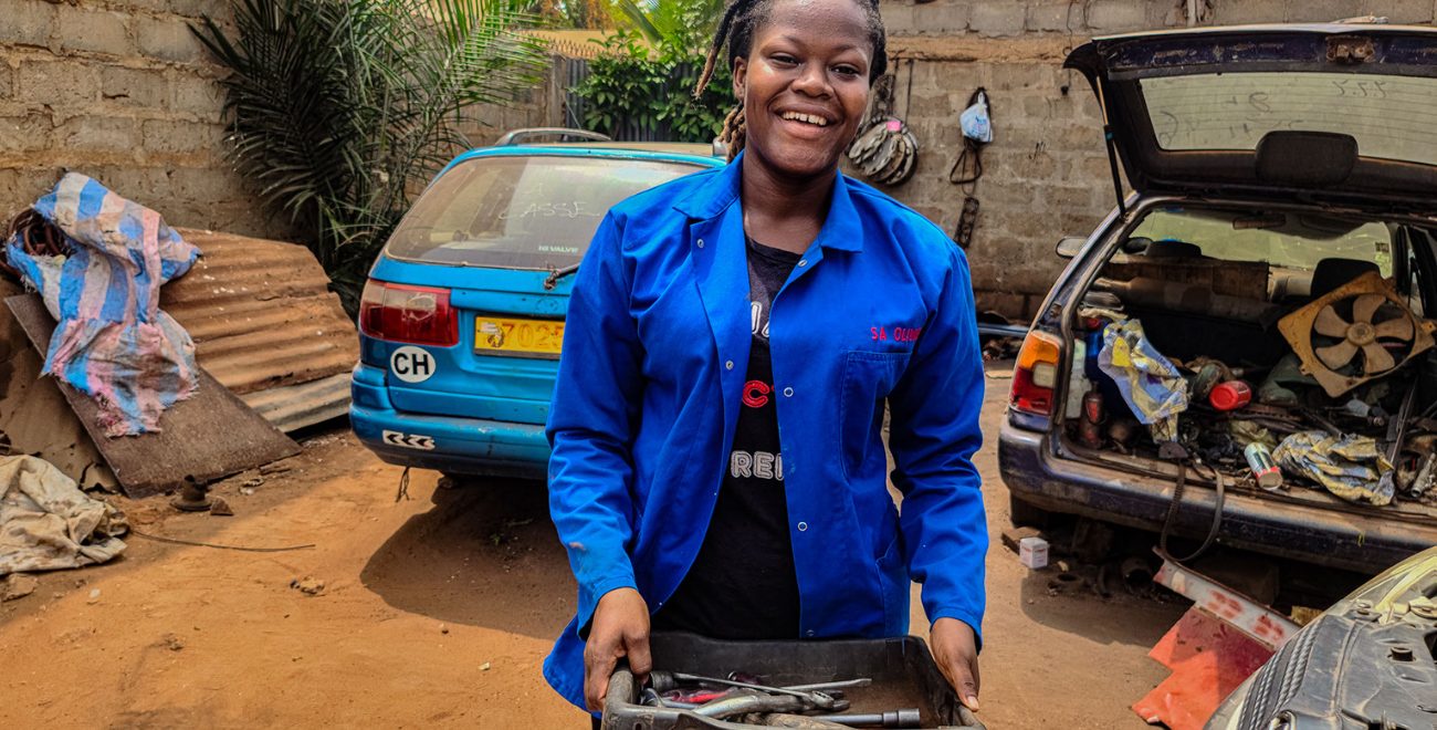 Winner stands smiling with her toolbox.