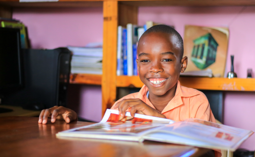 Wendyj, a boy from Haiti, reads a magazine