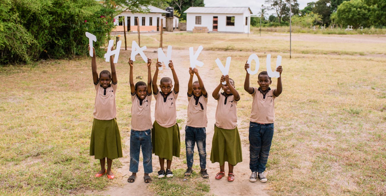 Children hold a sign saying thank you