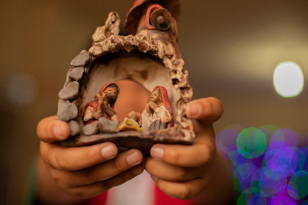 Fidel from Bolivia is holding a small nativity scene in his hands.